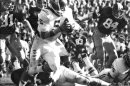 In this Nov. 15, 1975 file photo, University of Oklahoma quarterback Steven Davis (5) sweeps for a 15-yard gain against Missouri in Columbia, Mo. A University of Oklahoma official says the starting quarterback for Oklahoma's national championship teams in 1974 and 1975 is one of two men killed when a small plane slammed into a house in northern Indiana. St. Joseph County Coroner Randy Magdalinski identified the victims of Sunday's march 17, 2013 crash as 60-year-old Steven Davis and 58-year-old Wesley Caves, both of Tulsa, Okla. (AP Photo/The Oklahoman, Jim Arego, File)