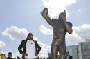 Washington Redskins quarterback Robert Griffin III looks at a bronze statute of himself after it was unveiled outside the new McLane Stadium before an NCAA college football game between SMU and Baylor Sunday, Aug. 31, 2014, in Waco, Texas. Griffin won the Heisman Trophy when he played at Baylor. (AP Photo/LM Otero)