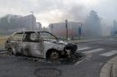 The shell of a burnt out car is seen in a neighborhood of Amiens, France, Tuesday, Aug. 14, 2012. Dozens of young men rioted in a troubled district in northern France after weeks of tensions, pulling drivers from their cars and stealing the vehicles, and burning a school and a youth center. The police department in Amiens says at least 16 officers were hurt by the time the riot ended Tuesday, some by buckshot. (AP Photo/Georges Charrieres)