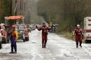 Rescue workers stand near a blocked portion of Highway 530 as search work continues after mudslide that struck Oso