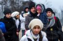 Migrants and refugees walk to cross the Macedonia-Serbia border near the village of Tabanovce, on February 4, 2016