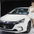 A model stands next to China's BYD QIN at Auto China 2012 in Beijing