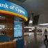 A woman working at Larnaca's airport walks past a small branch of Bank of Cyprus inside the airport in Larnaca