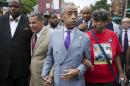 The Rev. Al Sharpton, second from right, walks with former New York Gov. David Paterson, second from left, and Gwen Carr, right, mother of Eric Garner, as they arrive before a march to protest the death of Eric Garner, Saturday, Aug. 23, 2014, in the Staten Island borough of New York. The afternoon rally and march was led by Sharpton and relatives of Garner, who died July 17 after a New York Police Department officer took him to the ground with a banned tactic in a confrontation captured on video. (AP Photo/John Minchillo)