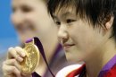 China's Ye Shiwen holds her gold medal up after winning the women's 200-meter individual medley swimming final at the Aquatics Centre in the Olympic Park during the 2012 Summer Olympics in London, Tuesday, July 31, 2012. (AP Photo/Daniel Ochoa De Olza)