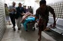 Yemenis transport a severely injured man on a gurney as he arrives at a hospital in Sanaa after being injured when two suicide bombers hit a Shiite mosque in quick succession, September 2, 2015