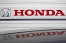 Logo of Honda Motor Co is reflected on roof of vehicle at Honda dealer in Kawasaki