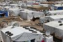 A Syrian refugee woman walks in a makeshift refugee camp in the eastern Lebanese town of Dalhamiyah on May 30, 2014