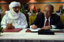 Algerian Foreign Minister Ramtane Lamamra (R) sign documents overseeing a peace agreement between the Malian government and armed groups on February 19, 2015 in Algiers