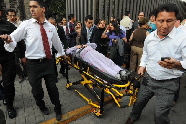 An injured person is transported on a stretcher the headquarters of state oil giant Pemex in Mexico City January 31, 2013. An explosion rocked the Mexico City headquarters of Pemex on Thursday, killing one person, injuring more than 20 others and causing extensive damage to the building. A local emergency official said one person had died in the blast and 22 others were injured. Another four people were trapped inside the skyscraper, the official said. The blast, which media reports said was caused by machinery exploding, occurred in the basement, emergency officials said. REUTERS/Alejandro Dias (MEXICO - Tags: DISASTER ENERGY POLITICS TPX IMAGES OF THE DAY)