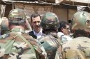 Syria's President Assad chats with military personnel during his visit to a military site in the town of Daraya