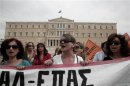 Protesters shout slogans during a rally by high school teachers against layoffs in their sector in front of the parliament in Athens