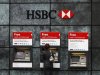 A woman uses a cash point machine at a HSBC bank in the City of London