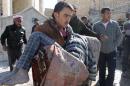 A man carries a body following a reported Syrian government forces air strike in the northern city of Aleppo on February 4, 2014