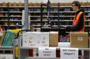 Worker supervises items for delivery from warehouse floor at Amazon's new distribution center in Brieselang