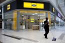 A worker sweeps past an outlet of South Africa's MTN Group in Johannesburg