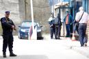 Bosnian policemen secure a perimeter around a crime scene at the police station in eastern Bosnia town of Zvornik, on April 28, 2015