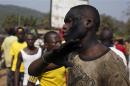A man with charcoal smeared on his face reacts as a crowd barricades a street during a dispute between members of the local Christian community and ex-Seleka soldiers in Bangui
