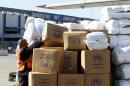 A worker arranges parcels of emergency relief provided by the United Nation's Refugee Agency (UNHCR) after they were unloaded from a cargo aircraft in Damascus, on February 13, 2014
