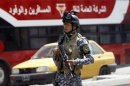 An Iraqi police officer stands guard at a checkpoint in central Baghdad on July 24