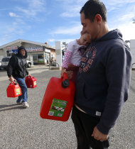 Chris Ferrone, right, carries his 3-year-old daughter Kora as she holds on to a five-gallon gas can while waiting in line to fill up at a gas station in Toms River, N.J. Thursday, Nov. 1, 2012. Motorists across New Jersey faced a second day of stressful, enormous lines Thursday at the gas stations that still had both electricity and supplies, as power outages kept many pumps out of service and tough travel made fuel deliveries difficult. (AP Photo/Julio Cortez)