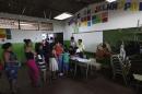 Voters wait in line to cast their votes in the presidential elections at a polling station outside in San Salvador