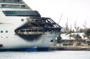 The fire-damaged exterior of Royal Caribbean's Grandeur of the Seas cruise ship is seen while docked in Freeport, Grand Bahama island, Monday, May 27, 2013. Royal Caribbean said the fire occurred early Monday while on route from Baltimore to the Bahamas on the mooring area of deck 3 and was quickly extinguished. All 2,224 guests and 796 crew were safe and accounted for. (AP Photo/The Freeport News, Jenneva Russell)