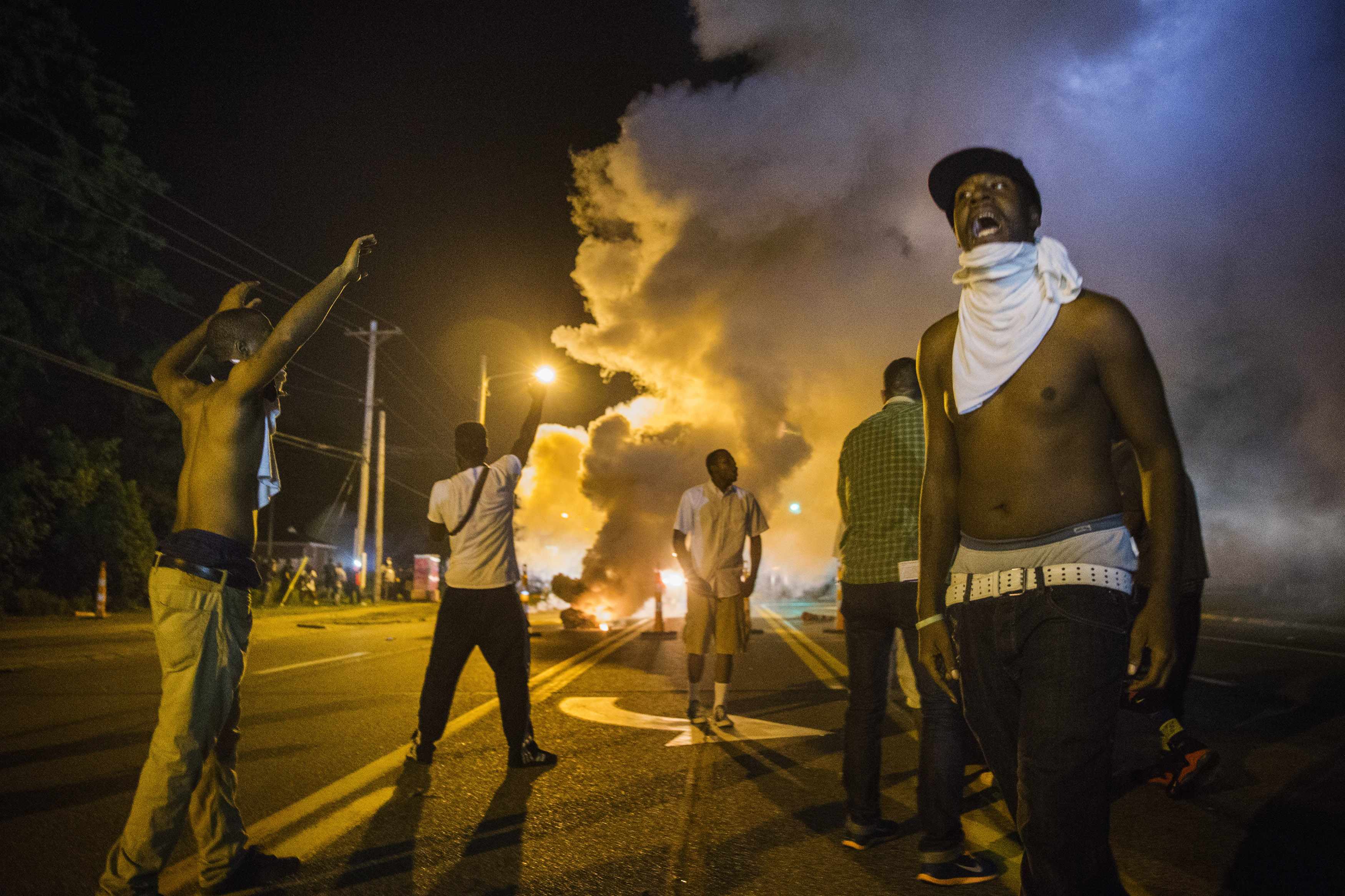 Demonstrators in Ferguson react to tear gas fired by police on Aug. 18 during protests over the fatal shooting of teenager Michael Brown. (REUTERS/Lucas Jackson) 