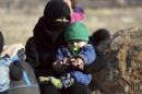 A Syrian woman holding a child who were evacuated from the embattled Syrian city of Aleppo during the ceasefire arrive at a refugee camp in Rashidin, near Idlib, Syria, early Monday, Dec. 19, 2016. The Security Council on Monday approved the deployment of U.N. monitors to the Syrian city of Aleppo as the evacuation of fighters and civilians from the last remaining opposition stronghold resumed after days of delays. (AP Photo)