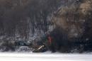 A freight train owned by Canadian Pacific Railway, carrying ethanol fuel with one car engulfed in flames, sits on the banks of the Mississippi River in a remote location north of Dubuque