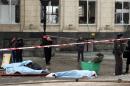 The covered bodies of victims lie on the ground as Russian security personnel inspect the damage at a train station following a suicide attack in Volgograd, on December 29, 2013