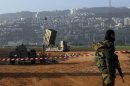 An Israeli soldier stands guard next to an Iron Dome rocket interceptor battery deployed near Haifa