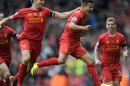 Liverpool's Philippe Coutinho right, celebrates with team-mate Steven Gerrard left, after he scores the third goal of the game for his side during their English Premier League soccer match against Manchester City at Anfield in Liverpool, England, Sunday April. 13, 2014. (AP Photo/Clint Hughes)