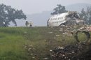 Fire crews investigate where a UPS cargo plane lies on a hill at Birmingham-Shuttlesworth International Airport after crashing on approach, Wednesday, Aug. 14, 2013, in Birmingham, Ala. Toni Herrera-Bast, a spokeswoman for Birmingham's airport authority, says there are no homes in the immediate area of the crash. (AP Photo/Butch Dill)