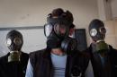 Volunteers wearing gas masks during a class on how to respond to a chemical attack, in the northern Syrian city of Aleppo on September 15, 2013