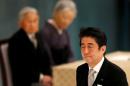 Japan's Prime Minister Shinzo Abe walks past Japan's Emperor Akihito and Empress Michiko during a memorial service ceremony marking the 70th anniversary of Japan's surrender in World War Two at Budokan Hall in Tokyo