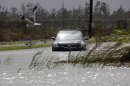 A car sits stranded in rising floodwaters from Isaac, which is expected to make landfall in the region as a hurricane this evening in Venice, La., the southernmost tip of the state, Tuesday, Aug. 28, 2012. Venice is outside the storm protection system and has been under mandatory evacuation. Forecasters at the National Hurricane Center warned that Isaac, especially if it strikes at high tide, could cause storm surges of up to 12 feet (3.6 meters) along the coasts of southeast Louisiana and Mississippi and up to 6 feet (1.8 meters) as far away as the Florida Panhandle. (AP Photo/Gerald Herbert)