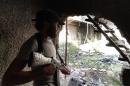 A rebel fighter guards a front line position in a rebel-held suburb of Damascus on August 23, 2014
