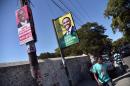 Election posters of presidential candidates Jovenel Moise (L) and Jude Celestin are seen in the commune of Petion Ville, Port-au-Prince, on December 22, 2015