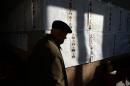 A man looks at information posters of the candidates for Ukraine's parliamentary elections on voting day in a polling station in Kiev on October 26, 2014