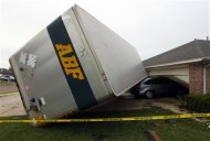 A trailer blown into a home on Lindsay Lane in Cleburne rests on a car after a tornado touch down in Cleburne, Texas May 16, 2013. REUTERS/Richard Rodriguez