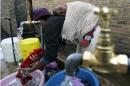 A mother washes her laundry at an open air wash place on May 19, 2006 in South Africa's Soweto township