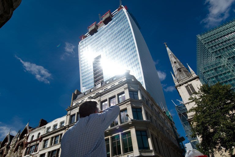 A man reacts to sunlight reflected from the windows of London's new "Walkie Talkie" tower in on August 30, 2013
