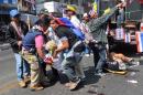 File photo of anti-government protesters helping a fellow protester injured in a grenade attack during a rally in Bangkok