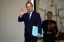 French president Francois Hollande waves after the weekly cabinet meeting on December 23, 2013, at the Elysee presidential palace