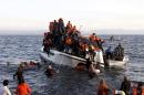 Refugees, most of them Syrians, struggle to leave a half-sunken catamaran carrying around 150 refugees as it arrives on the Greek island of Lesbos