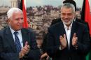 Palestinian Fatah delegation chief Azzam al-Ahmed (left) celebrates with Hamas prime minister Ismail Haniya after a signing ceremony in Gaza City, on April 23, 2014