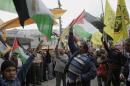 Palestinians wave its flags and Fatah's during a rally in support of Palestinian President Mahmoud Abbas in the West Bank city of Nablus on Wednesday, April 2, 2014. (AP Photo/Nasser Ishtayeh)