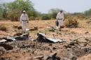 Investigators gather evidence at the crash site of the Air Algerie flight AH5017 in Mali's Gossi region, on July 29, 2014
