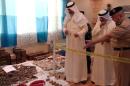 A photo released by the Kuwaiti news agency KUNA on August 13, 2015, shows Interior Minister Sheikh Mohammad al-Khaled al-Sabah (C) alongside a policeman looking at seized weapons in Kuwait City